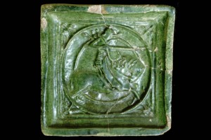 Halbzylinderkachel mit geschlossenem Vorsatzblatt mit Ritter beim Gestech in rundem Medaillon mit glattem Band, grün glasiert, um 1450, Straßburg, Musée Historique, Inv.-Nr. 10008