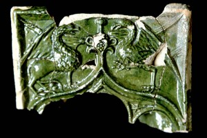 Fragment einer Nischenkachel mit durchbrochenem Vorsatzblatt und Kielbogen mit Greifen, grün glasiert, vor 1450, Hirschhorn, Museum