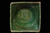 Fragment einer Napfkachel mit glatt abgestrichenem Rand und einer Kreuzigungsgruppe auf dem Boden, grün glasiert, 16. Jh., H. 18,0 cm, Br. 18,0 cm, Innsbruck, Tiroler Volkskundemuseum
