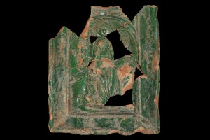 Fragment einer Nischenkachel mit geschlossenem Vorsatzblatt mit der knienden, lesenden Maria aus einer zweiteiligen Verkündigungsdarstellung vom Typ 1, grün glasiert, H. 20,5 cm; Br. 18,0 cm; Oberrhein, um 1450, Karlsruhe-Durlach, Privatbesitz, urspr. vom Areal "Lederkromer"