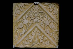Fragment einer Bodenfliese mit Tapetendekor mit Akanthusrosetten und rechtwinkligem, rankenbesetztem Band, gelb glasiert, Anfang 17. Jh., H. 18,0 cm, Br. 18,0 cm, Saverne, Musée de Saverne