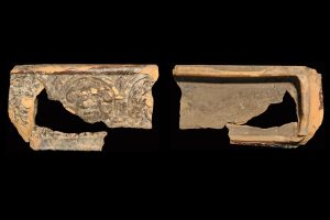 Fragment einer Gesimskachel mit Löwenköpfen in pfeilbesetzter Arkade, dunkelbraun glasiert, erstes Drittel 17. Jh., H. 10,3 cm, Br. 18,6 cm, Bad Neustadt an der Saale, Museum