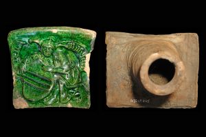 Fragment einer Kranzkachel mit kniendem Narren, grün glasiert, ca. 1450, H. 16,0 cm, Br. 18,7 cm, Großostheim, Bachgau-Museum, Inv.-Nr. 430 49 005