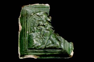 Fragment einer Blattkachel mit Samson als Löwenbezwinger mit Schriftband "SIMSON", grün glasiert, ca. 1450; Br. 19,0 cm; Geislingen, Museum im Alten Bau